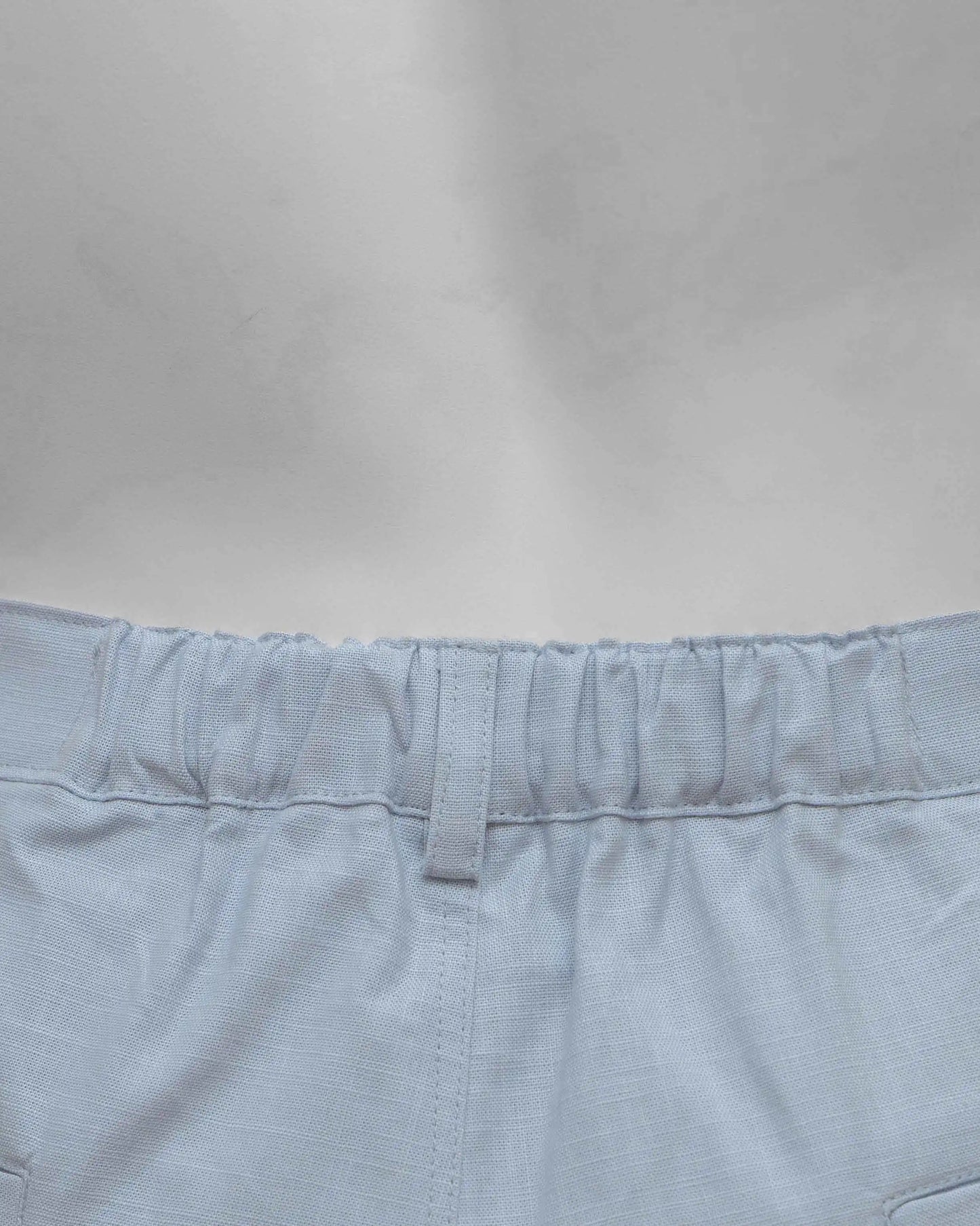 Close up of the waistband of NAD's sky blue cotton pants for men.