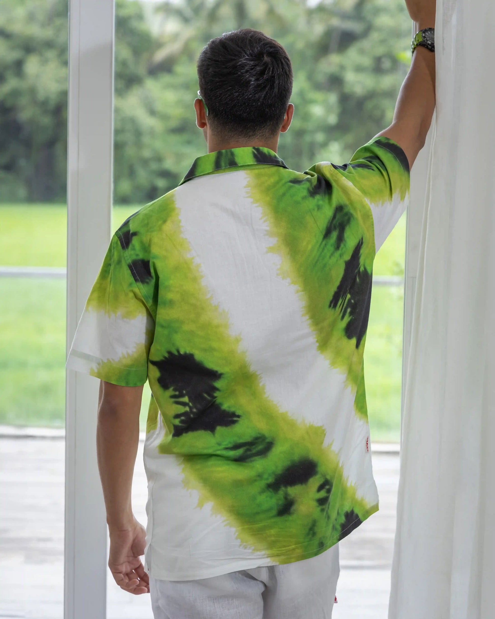  Back shot of a model wearing NAD's tie-dye shirt for men.