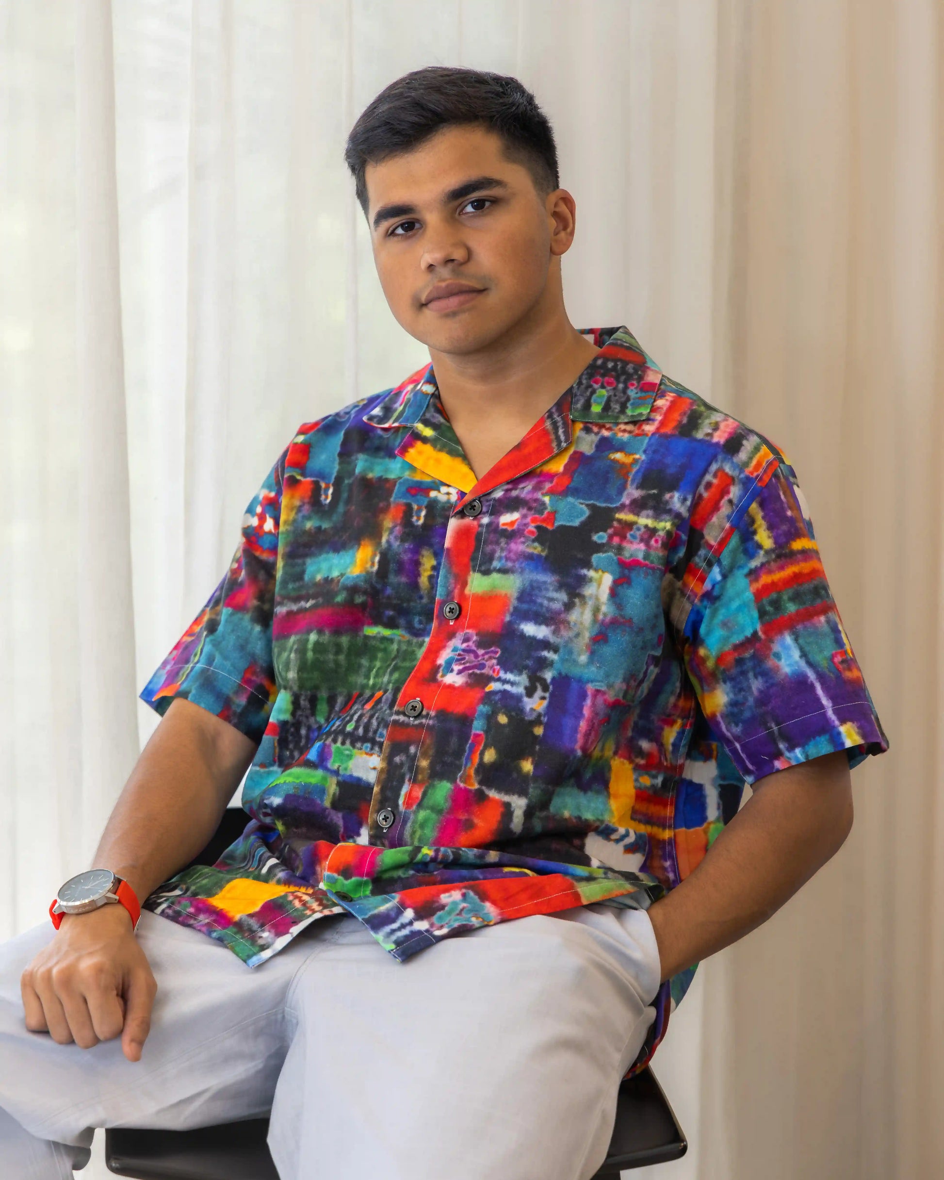  A man in NAD's vibrant, abstract multi-colored printed shirt for men.